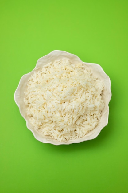 Weißer gekochter Reis in schöner Schüssel auf Grün