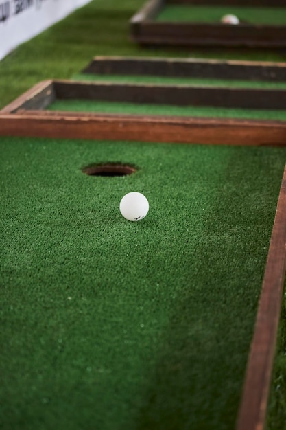 Weißer Golfball in der Nähe des Lochs Golfball am Loch Golfball ist im Loch