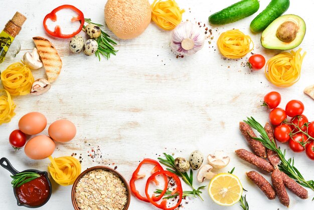 Weißer Hintergrund aus Holz Lebensmittel Tomaten Pasta Gewürze Gemüse und Würstchen Ansicht von oben