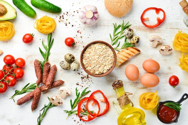 Weißer Hintergrund aus Holz Lebensmittel Tomaten Pasta Gewürze Gemüse und Würstchen Ansicht von oben