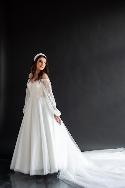 Weißer Hintergrund des langen Hochzeitskleides der Braut