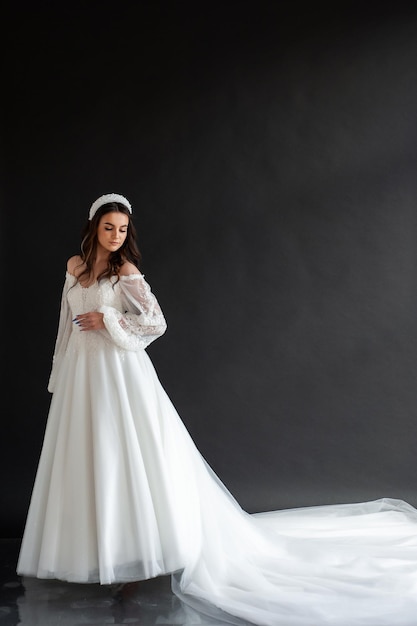 Weißer Hintergrund des langen Hochzeitskleides der Braut