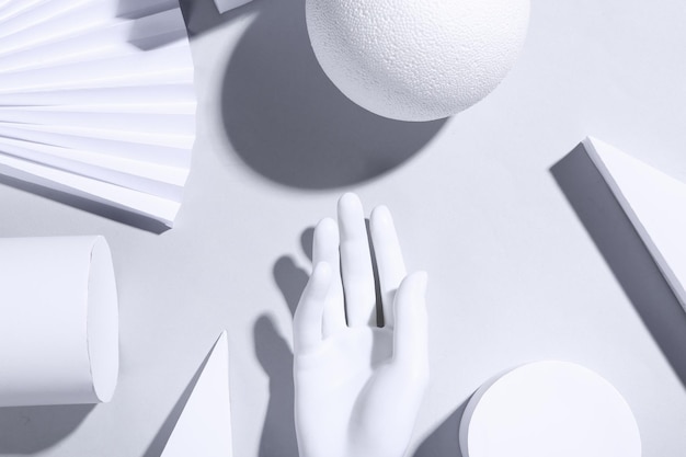 Weißer Hintergrund des Minimalismus mit geometrischen Formen und Mannequinhänden Trendige Schatten