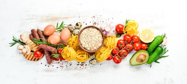 Weißer hölzerner Hintergrund Tomaten Pasta Gewürze Gemüse und Würstchen Ansicht von oben
