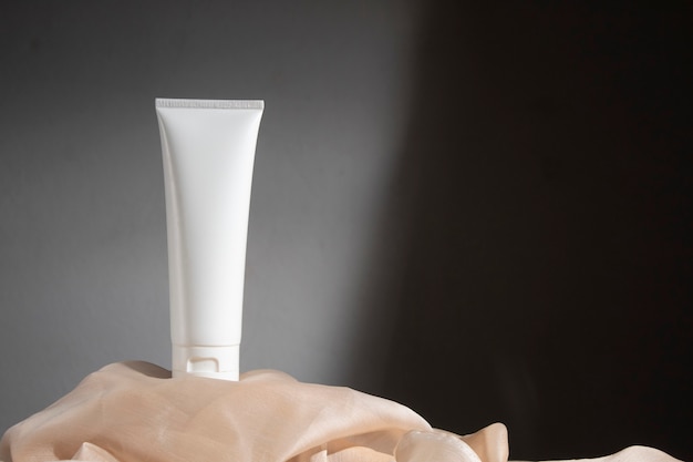 Weißer Holztischhintergrund mit Stoffgewebe, kosmetisches Make-up-Flaschenlotionscremeprodukt mit Schönheitsmode-Hautpflegegesundheitsmodell