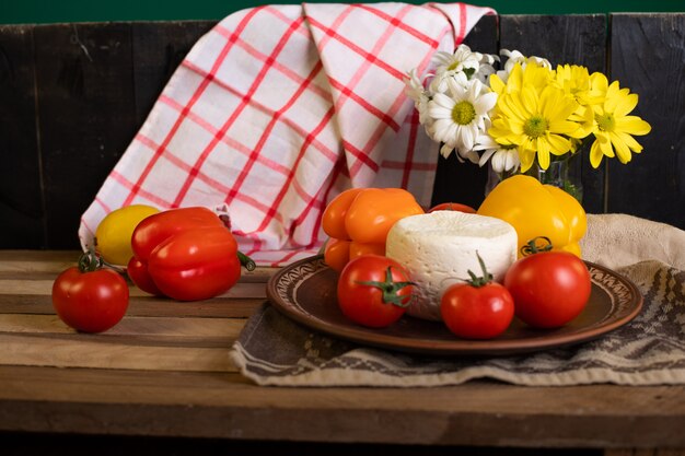Weißer Käseteller mit Tomaten und Paprika