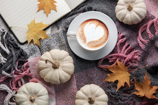 Weißer Kürbiskaffee und Herbstlaub