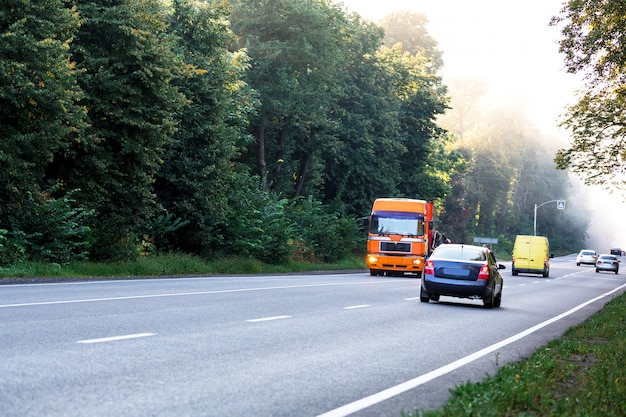 Weißer LKW auf der Straße in einer ländlichen Landschaft bei Sonnenuntergang ankommen