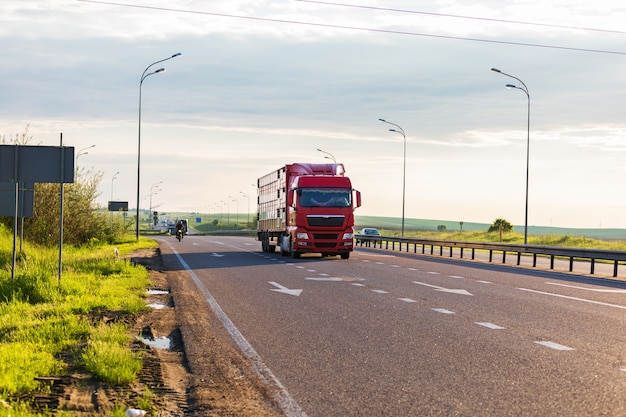 Weißer LKW auf der Straße in einer ländlichen Landschaft bei Sonnenuntergang ankommen