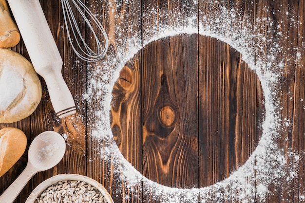 Weißer Rahmen gemacht mit Mehl und frischem Brot auf hölzernem Hintergrund