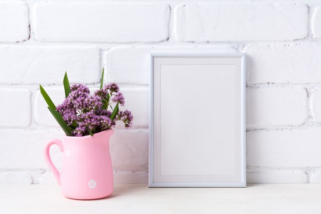 Weißer Rahmen mit lila Blumen im rosa rustikalen Krug