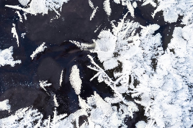 Weißer Raureif auf der Eisoberfläche des Sees. Makrobild. Schöner Winternaturhintergrund