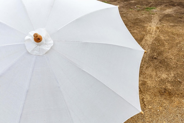 Weißer Regenschirm auf dem Boden