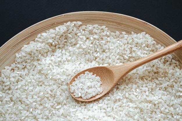 Weißer runder Reis im Holz- oder Bambuslöffel
