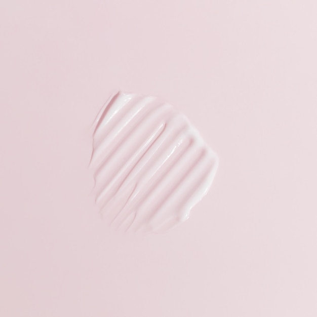 Weißer Schönheitscreme-Schmierfleck auf rosa Hintergrund Kosmetische Hautpflegeproduktstruktur