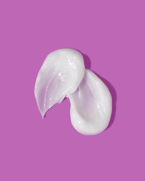 Weißer Schönheitscreme-Schmierfleck auf violettem Hintergrund Kosmetische Hautpflegeproduktstruktur