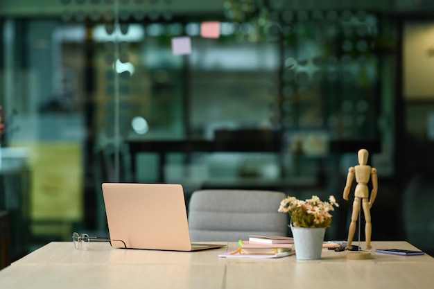 Weißer Schreibtisch mit Laptop-Brillen, Notizbüchern und Blumentopf