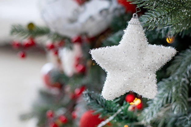 Foto weißer stern und andere dekorationen auf dem weihnachtsbaum verwischen