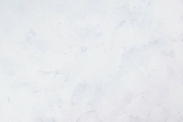 Weißer strukturierter Hintergrund aus Füllpaste, die mit einem Spachtel in unregelmäßigen Strichen aufgetragen wird