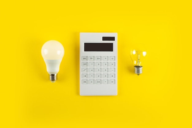 Weißer Taschenrechner und Glühlampe oder LED-Birne auf gelbem Hintergrund Konzept, das die Zahlung zeigt