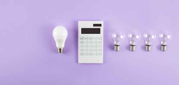 Weißer Taschenrechner und Glühlampe oder LED-Lampe auf violettem Hintergrund Konzept, das die Zahlung zeigt