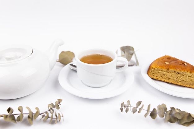 Weißer Tee-Set mit Teekanne Tee und Untertassen und Kuchen zum Frühstück