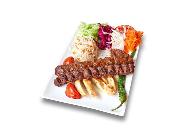 Weißer Teller mit Adana Kebab und Gemüse, isoliert auf weiss