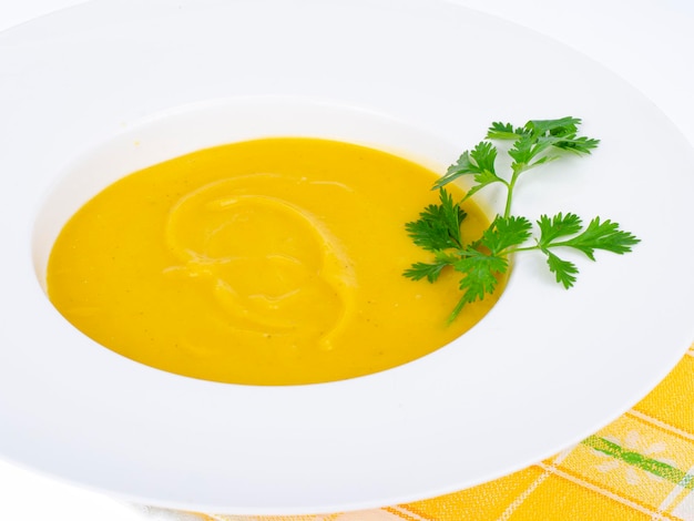 Weißer Teller mit dicker Kürbiscremesuppe. Studiofoto