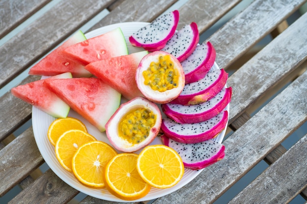 Weißer Teller mit geschnittenen Früchten. Frisches Obst und Vitamine. Stillleben gefärbte Sommerfrüchte.