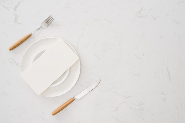 Weißer Teller ohne Essen mit Gabel und Messer