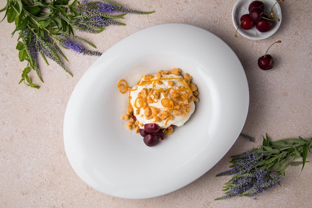 Weißer Teller und Kuchen auf grauem Hintergrund Weißer Sahnehonigkuchen mit Walnüssen