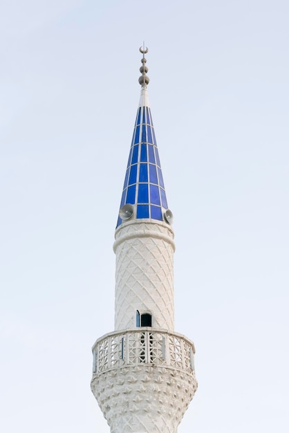 Weißer Turm der Moschee vor dem blauen Himmel