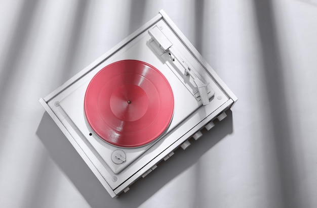 Weißer Vinyl-Plattenspieler auf grauem Hintergrund mit trendiger gestreifter Schatten-DJ-Ausrüstung Minimalistisches Musikkonzept Kreatives Layout