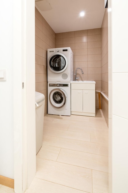 Weißes Badezimmer mit Aufsatzwaschbecken und Waschmaschinen. Neues Interieur nach Reparaturkonzept. Stock Foto