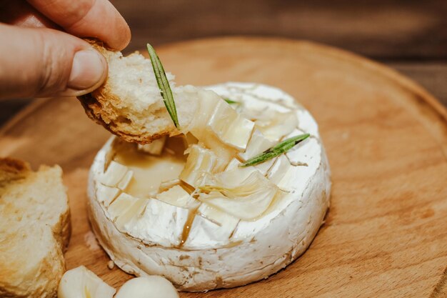 Weißes Baguette mit Olivenöl und gebackenem Camembert-Käse auf dem Tisch