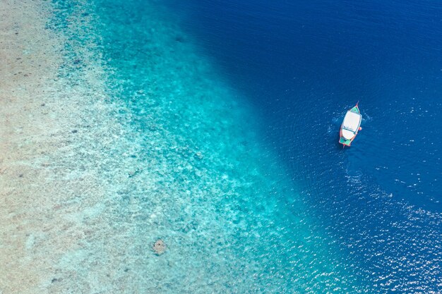 Weißes Exkursions-Tauchboot auf den Malediven. Erstaunliches Korallenriff und wunderschöne tropische Küstenlinie