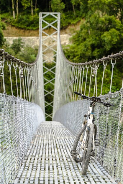 Weißes Fahrrad auf der Fußgängerhängebrücke geparkt