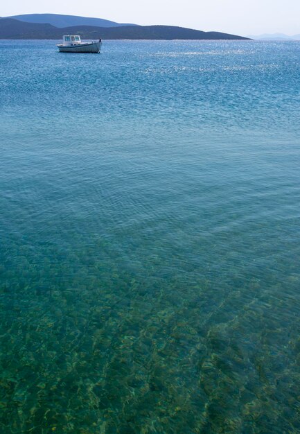 Weißes Fischerboot mit Markise im Hafen des griechischen Ferienortes Marmari in Griechenland