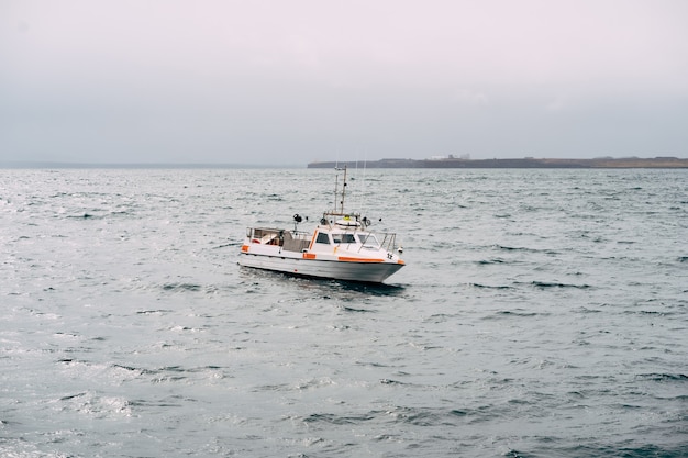 Weißes fischermotorboot segelt über den atlantik in island-seitenansicht