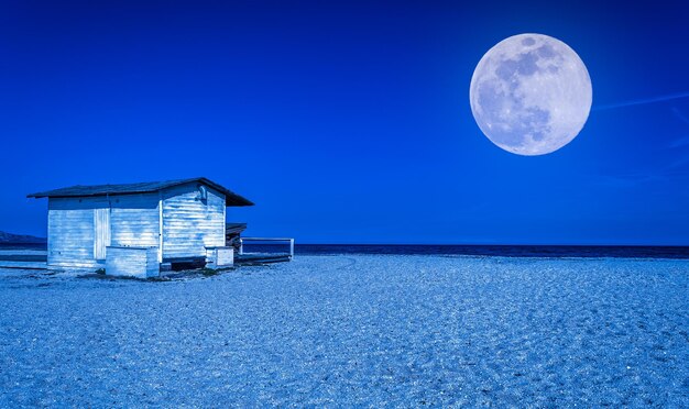 Weißes Häuschen am Strand bei Nacht