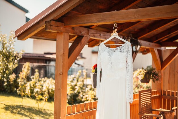 Weißes Hochzeitskleid draußen in den Hochzeitsdetails des grünen Tages des Sommers