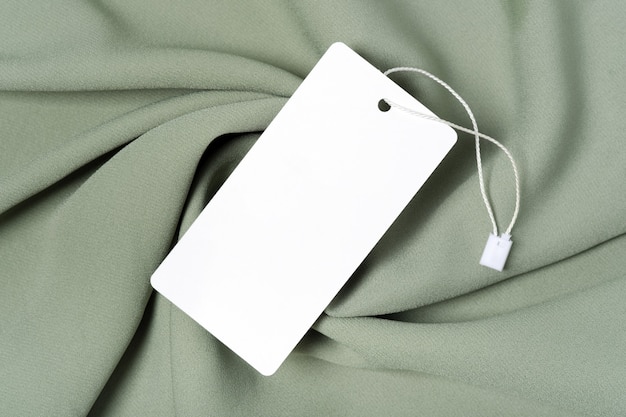 Weißes Kleidungsetikett, leere Mockup-Vorlage beschriften. Auf einem hochwertigen baumwollgrünen Khaki-Stoff-Textil