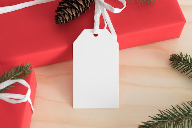 Foto weißes leeres tag-modell isoliert auf einem roten weihnachtsgeschenk