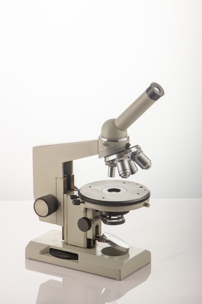 Weißes Mikroskop auf Tisch über Weiß