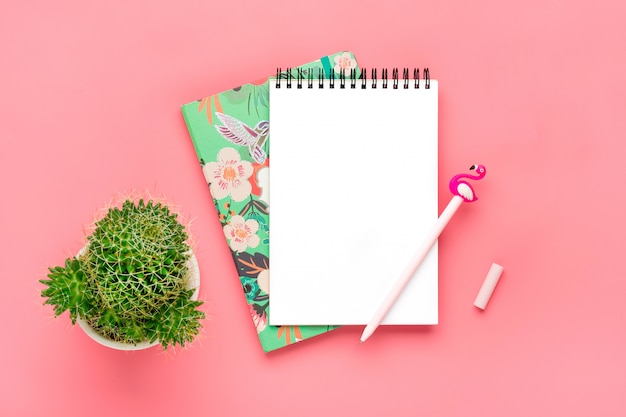 Weißes Notizbuch für Anmerkungen, Kerze, Stiftflamingo, Hauptblumensucculent, rosa Hintergrund