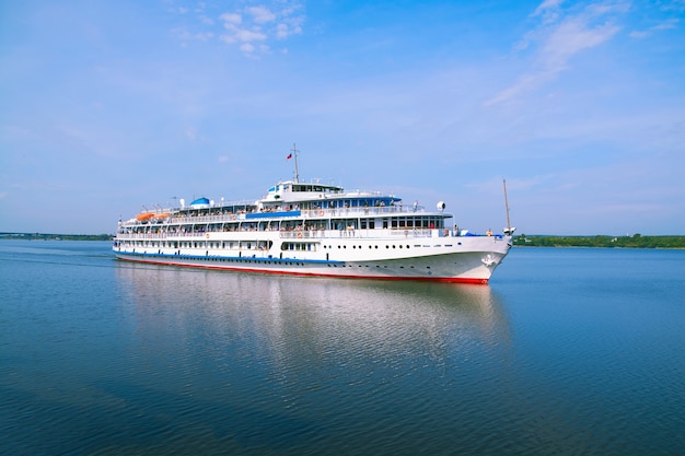 Weißes Passagierschiff, das auf dem Fluss schwimmt