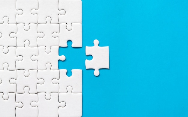 Weißes Puzzle auf blauem Hintergrund. Team Business Erfolgspartnerschaft oder Teamarbeit.