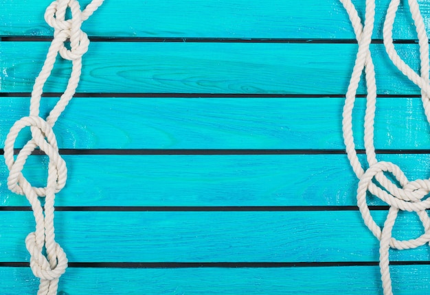 Weißes Seil auf blauem hölzernem Beschaffenheitshintergrund. Reisekonzept