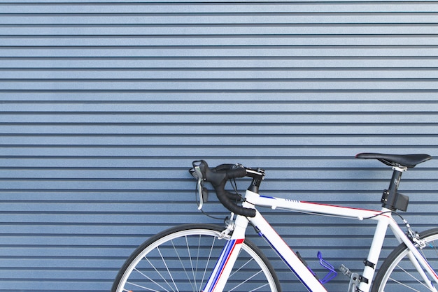 Weißes Straßenrad steht auf dem Hintergrund einer blauen Wand