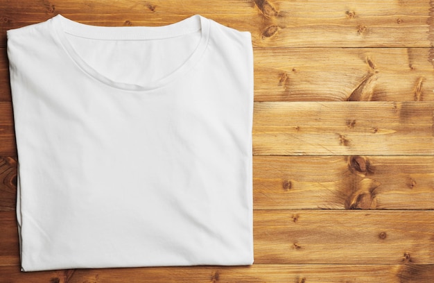 Weißes T-Shirt auf hölzernem Hintergrund